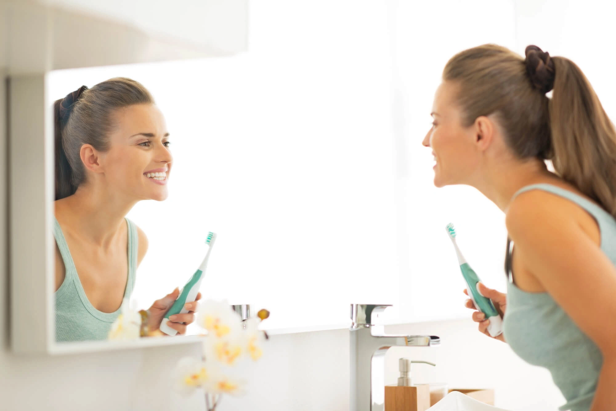 Woman brushing teeth after gum disease treatment palm beach gardens